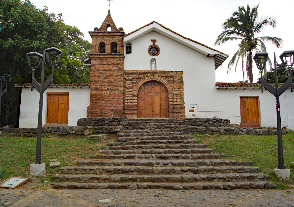 A small white church with bricks and stone steps