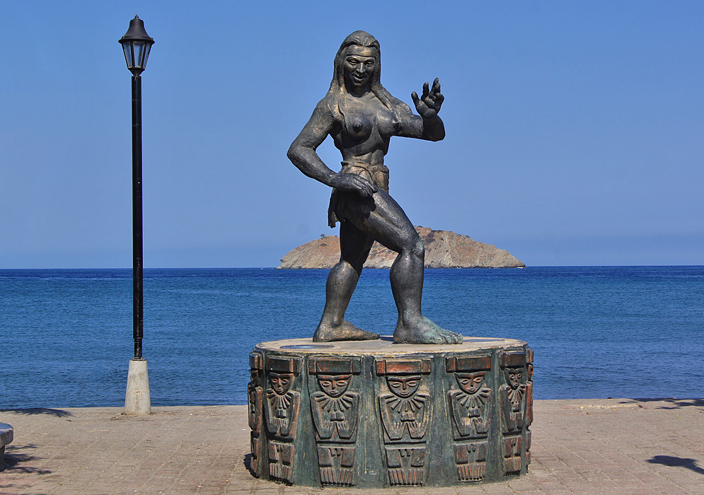 A statue of an Indian with a small rock island in the background