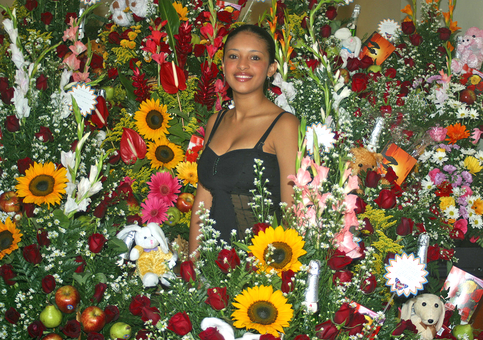 Colombian woman surrounded by cut flowers
