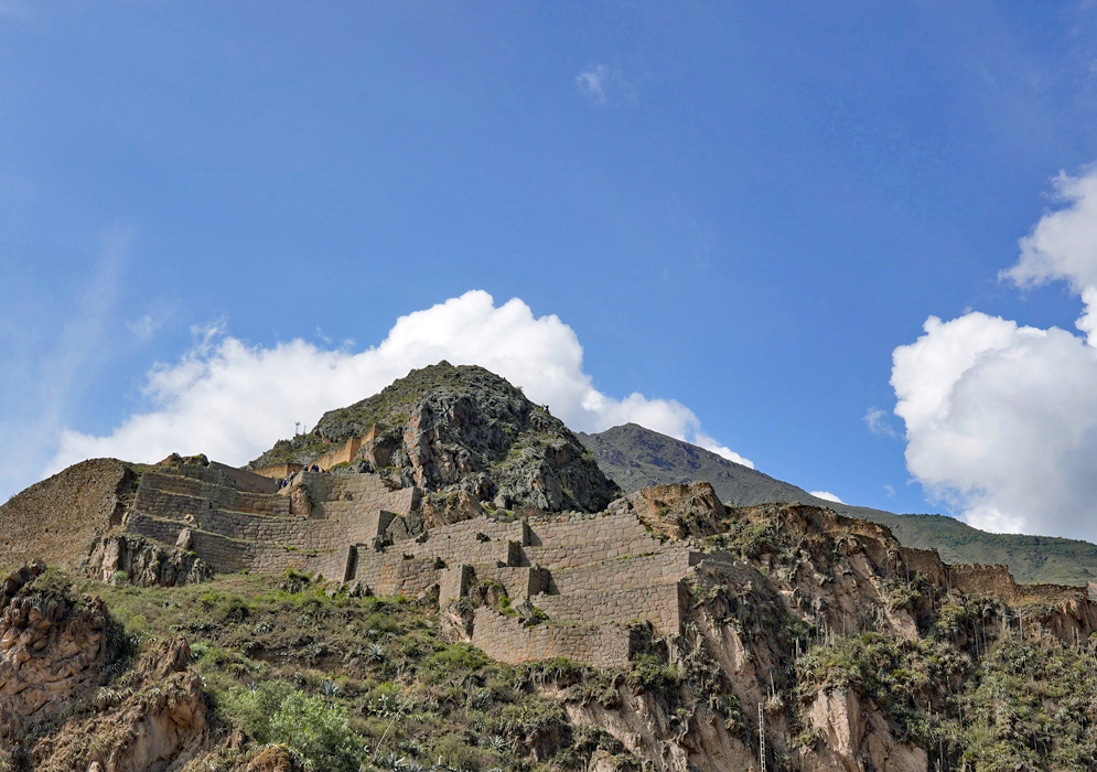 Temple Of The Sun Ollantaytambo Stone terraces and precisely cut walls of the Inca Temple of the Sun rising from a rocky outcrop in Ollantaytambo beneath a bright blue sky