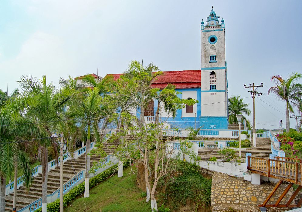 A blue and white church with a red roof  in Usiacuri, Colombia