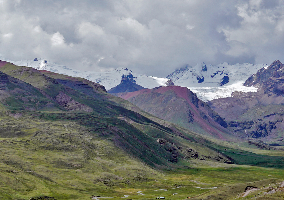Steep cliffs and winding valleys filled with native pine trees and a mountain stream define this highland stretch of the Vilcanota range