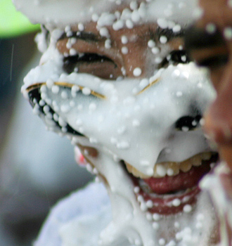 Carnival spectators covered in white foam